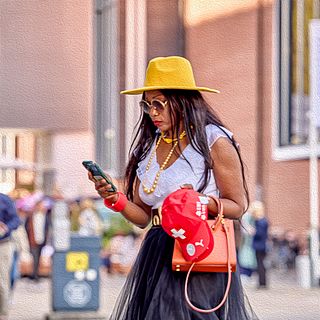 Woman with yellow hat, red bag and phone in hand walking outside Messe Basel – a stylish moment captured by Bluesun Event Photography.