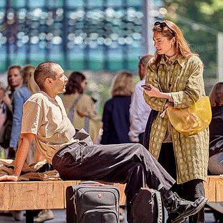 Two people chatting casually in front of the Art Basel entrance – a relaxed break moment captured by the Bluesun photo team.