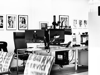 Eindruck vom modernen Design-Arbeitsplatz bei Bluesun in Basel mit Doppelmonitor, Spezial-Halterung und Canon Teleobjektiv – für Webentwicklung, Bildbearbeitung und kreative Prozesse.