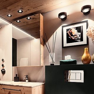 Detailed interior shot of a modern bathroom with wooden accents, mirror, fragrance sticks and art on the wall - photographed by Bluesun.