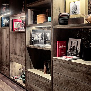 Stylishly furnished wooden bookcase with high-quality illustrated books and design objects - interior design photography by Bluesun.