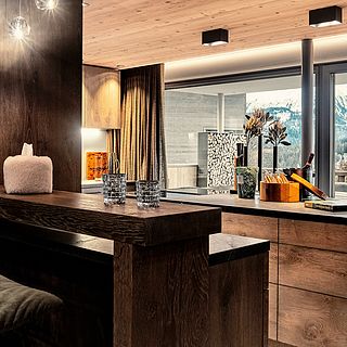 Atmospheric interior shot of a high-quality eat-in kitchen with wood paneling, stylish accessories and panoramic views - photographed by Bluesun Interior Design.