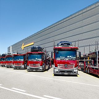 Galliker car transporter trucks in front of logistics hub, captured by Bluesun – professional Swiss corporate photography.