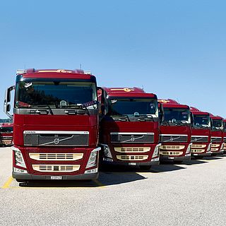 Front view of multiple red Volvo trucks from Galliker parked side by side, captured for Galliker Transport AG’s corporate image.
