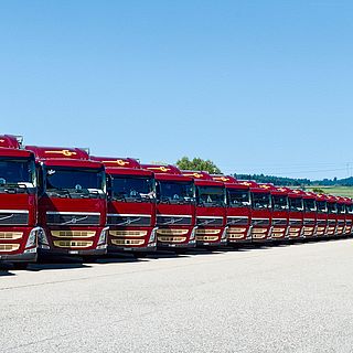 Row of red Volvo trucks from Galliker Transport AG on the company premises, photographed by Bluesun for a visual company presentation.