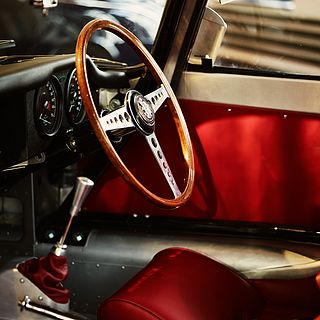 Close-up of a classic wooden steering wheel with red interior at Emil Frey Classic in Safenwil – captured by Bluesun for premium exhibition photography.