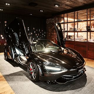 McLaren with gullwing doors at Schmohl Exclusive Cars in Weinfelden – staged by Bluesun for premium exhibition photography and brand impact.