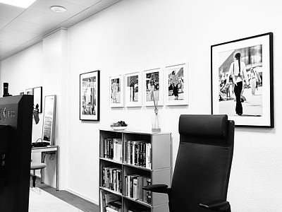 Vue de l’atelier Bluesun avec des tirages d’art encadrés, une étagère remplie de livres spécialisés et une ambiance de travail élégante.